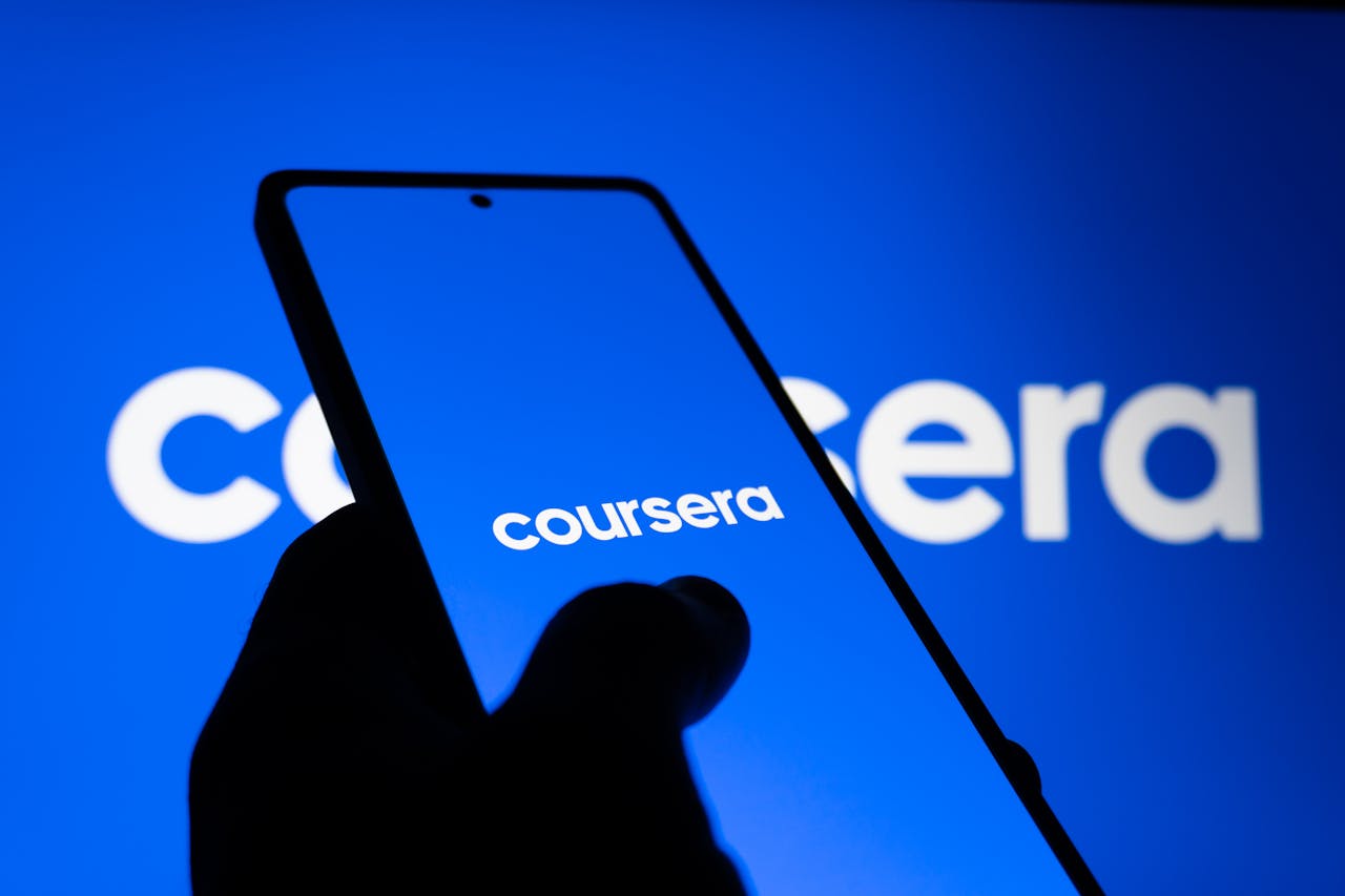 services-02 A smartphone displaying the Coursera logo against a bright blue background, symbolizing online learning.